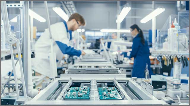 Shot of an Electronics Factory Workers Assembling Circuit Boards by Hand While it Stands on the Assembly Line.jpg