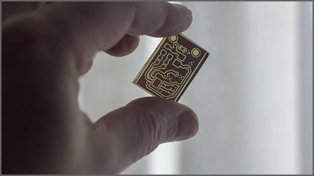 A printed circuit board held by a male hand.jpg