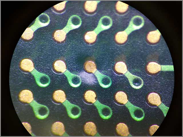 It demonstrates a microscopic view of PCB vias and pads.jpg