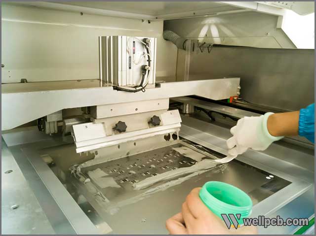  Worker holding solder paste with a spoon on PCB Processing machine.jpg