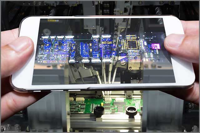 A cell phone is examining a printed circuit board.jpg