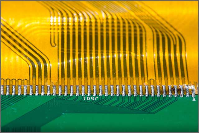Flexed printed circuit board in detail with connector pads.jpg