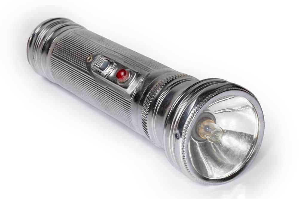 Old electric hand flashlight with metal housing