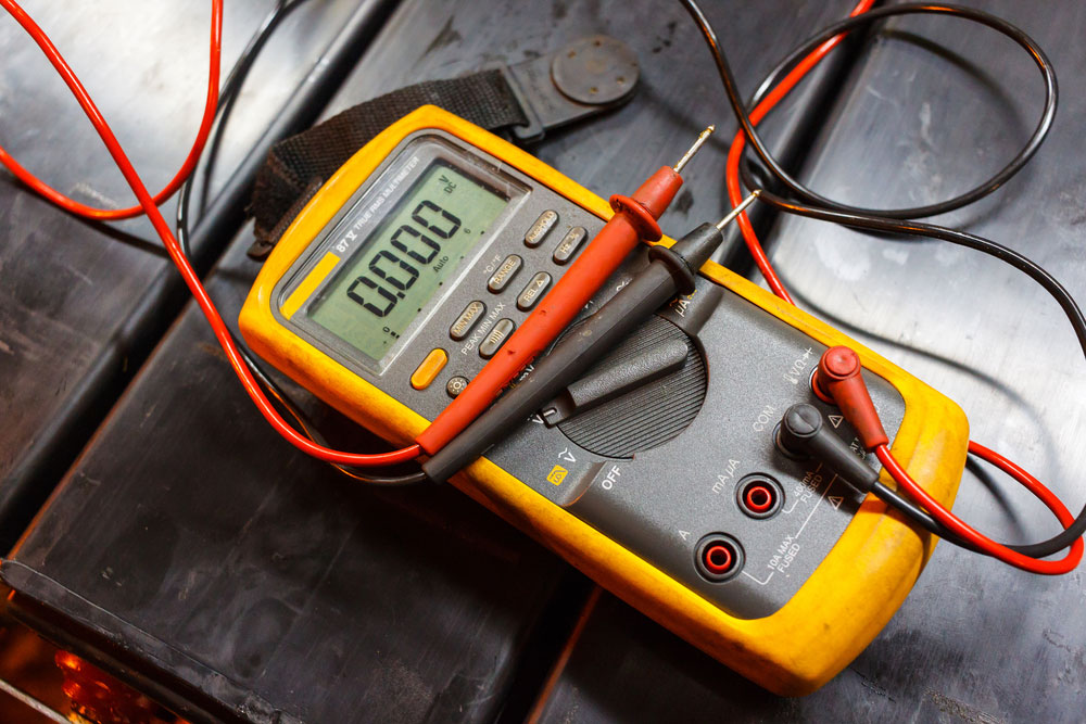 A multimeter tests the battery