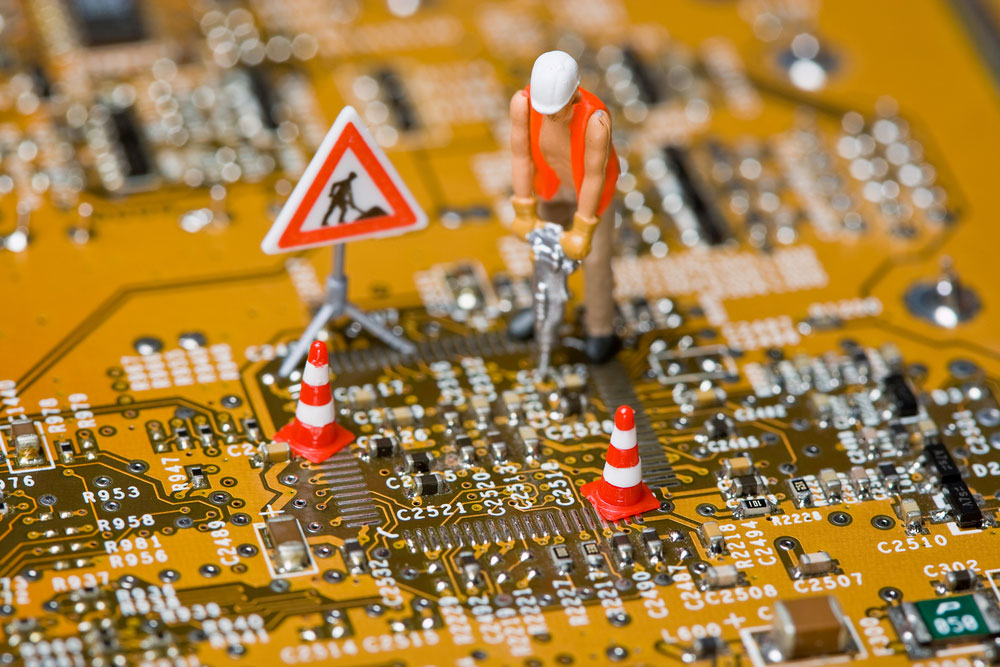 Image of miniature figures working on a circuit board