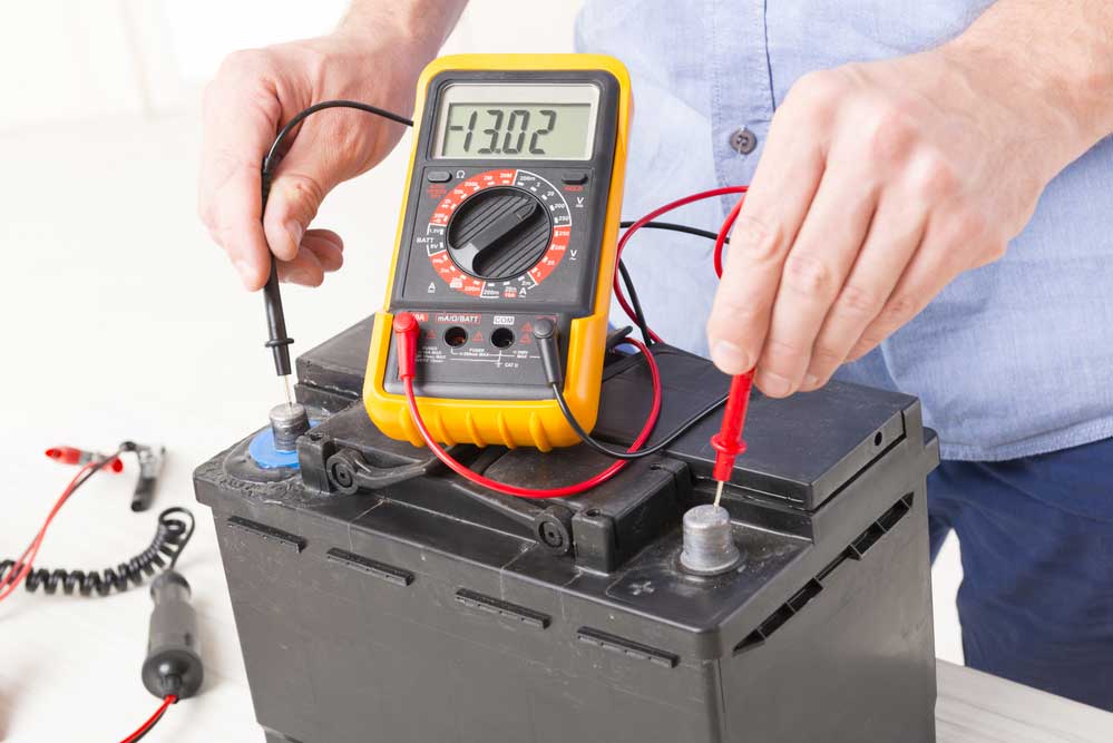 a digital voltmeter measuring the voltage of a battery