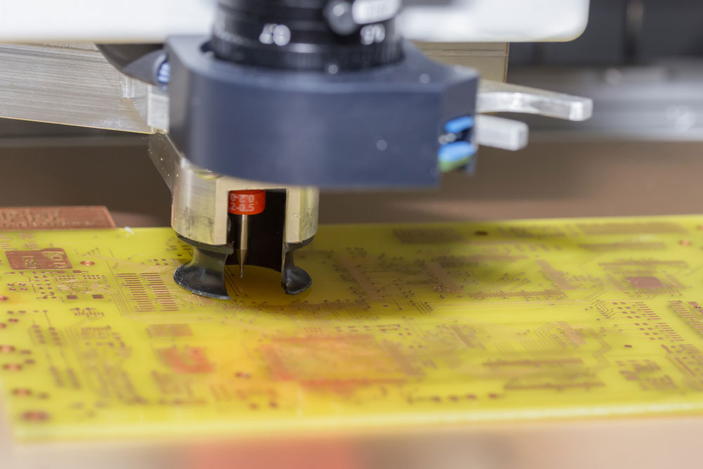 A machine drilling holes into a printed circuit board