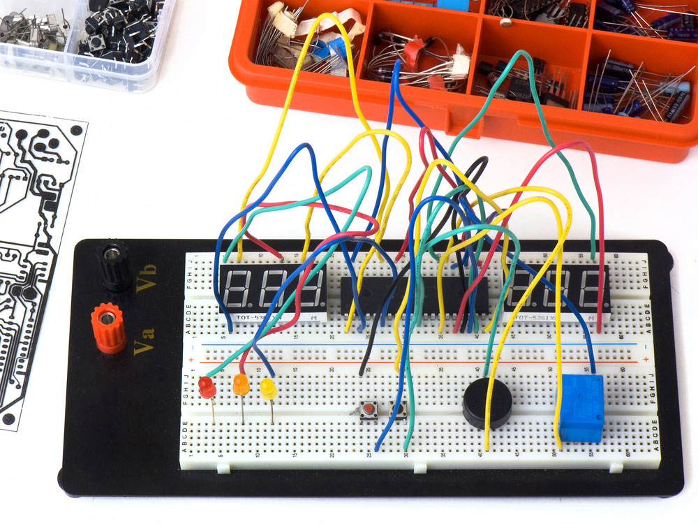 A white plastic breadboard connected with several electrical components
