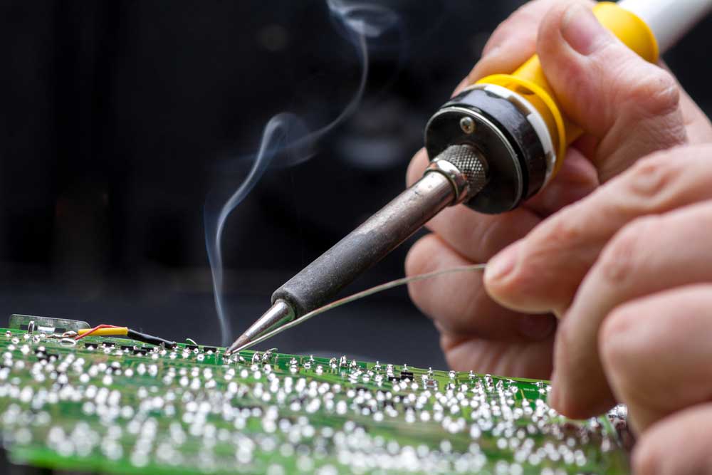 Hands soldering a PCB